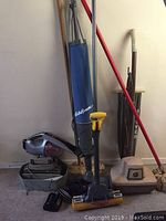 Photo showing the lot contents of vacuum cleaners, mop, broom, and metal bucket