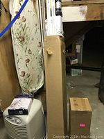 Photo of packaged shower spray parts and two cardboard boxes in storage area.