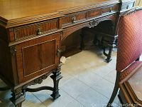 Sideboard left front quarter view showing carved legs, drawers and cabinet door with inlaid marquetry.