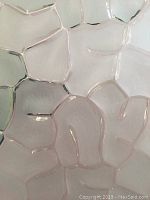 Close-up detail of the textured smoked glass showing the organic irregular geometric pattern with raised texture.