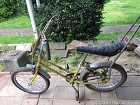 Yellow CCM Cheetah bicycle with visible rust and wear on frame, showing the bike's front and side profile and sissy bar.