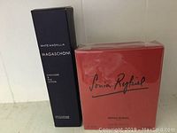 Photo shows two unopened boxed items: a red box with Sonia Rykiel Eau de Toilette and a black box labeled Magaschoni White Magnolia Cashmere & Silk Lotion.