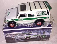 White and green Hess SUV on top of original box showing side profile and roof