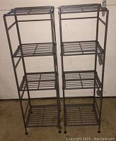 Two black collapsible metal shelves each with four slatted shelves, shown fully assembled side by side.