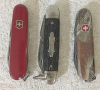 Top view showing all three knives in closed position, highlighting handle materials, logos, and keyrings