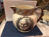 Full view of the cream-colored Wedgwood Etruria ceramic pitcher featuring a black portrait of Alfred Lord Tennyson, star details, and floral banner decorations.