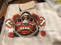Front view of the vintage carved and painted Indonesian Wayang or Bali mask showing detailed facial structure and colors.
