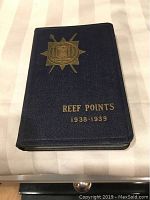 Front cover of 1938-1939 Reef Points book showing black cover with gold embossed emblem and text.