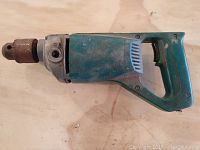 Side view of the Makita electric drill body with visible wear and missing power cord.