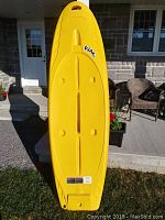 Top view of the yellow SUP board showing overall shape and deck pad