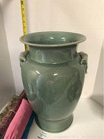 Front view of large green ceramic umbrella stand showing overall shape and crackle glaze finish