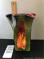Side view showing the colorful glass vase with scalloped top and a ruler for scale about 8 inches tall.