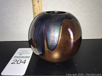 Photo of copper colored art glass vase with iridescent blue-purple patterns showing top and side view with measurement ruler