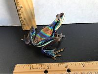 Side view of the signed art glass frog with ruler to show approximate size around 3 inches long and 2 inches wide