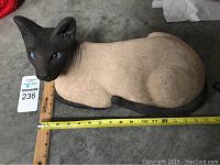Side angle showing full length of Siamese cat statue with measuring tape for size reference.