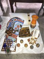 Full view of the collection showing wooden painted eggs along with decorative plates, vase, textile fabric, and other small items.