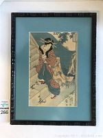 Full view of the framed artwork showing the subject seated on stone steps, frame, and matting.