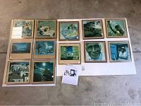 Photo showing all 12 framed photographs arranged on a flat surface, mixed subjects including portraits, landscapes, and abstract scenes.