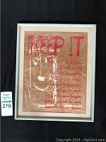 Front view of framed silk screen broadside print titled KEEP IT by Kenneth Patchen, with a red and white design on brown paper.