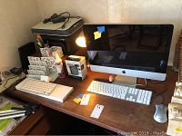 Desk overview showing iMac, printer, scanner, keyboard, mouse, router and desk accessories