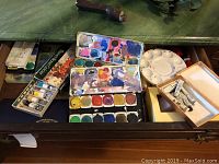 Watercolor paint sets with tubes and paint mixing palette inside a drawer