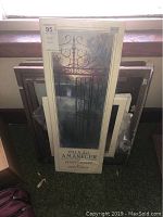 Unframed print titled 'Villa del Amanecer' leaning against stacked blank canvases.