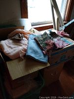 Boxes with assorted fabrics on top, near a window