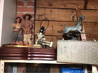 Photo showing two handmade fabric dolls and metal horse statue on a wooden shelf