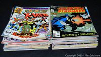 Two stacks of vintage comics with Marvel and DC titles including Obnoxio the Clown X-Men and The Phantom Stranger