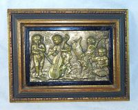 Full view of the framed brass relief plaque showing putti cherubs playing musical instruments