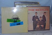 Photo showing multiple vinyl records including The Beatles At The Hollywood Bowl and Introducing The Beatles albums at front.
