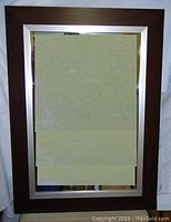Full view of large rectangular Pottery Barn mirror with wooden outer frame and satin metallic inner trim.