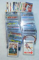 Wide shot of multiple stacks of sports cards, mostly baseball, in protective plastic covers laid out side by side.