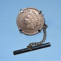 Front view of tie clip pin showing 1901 Indian Head penny mounted in metal prong setting, attached to chain and bar.