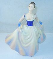 Front view of Royal Doulton figurine Lisa, showing the detailed blue bodice and flowing pastel-colored skirt.
