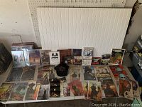 Long shot of the Stephen King collection arranged on a table including magazines, books, a hat, photographs, and CDs.