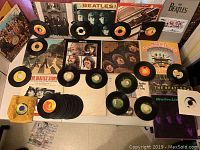 Wide view showing all vinyl records, album covers, and the Anthology book arranged on a flat surface.