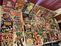 Image showing all 39 mixed comic books laid out on a table including titles from Marvel and DC.