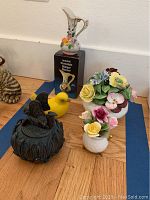 Overall lot of assorted porcelain and decorative figurines including pitcher, yellow bird, floral bouquets, and fairy jar