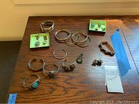 Entire grouping of 20 silver and turquoise jewelry pieces arranged on wood surface