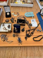 Overall assortment of vintage jewelry on table including pins, bracelets, necklaces, rings and earrings, some in boxes
