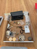 Overview of lot showing miniature beverage set, coins, jewelry, pen, watch, padlock and trinket box
