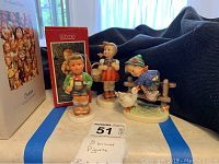 Three Hummel figurines with original Schmid box, displayed together showing condition and style.