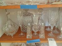 Wooden shelf displaying fluted glass decanter, stemware glasses, canister, and salt and pepper shakers.