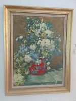 Full view of the floral print with red vase, framed and hung on a wall.