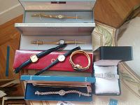 Group shot of seven watches with boxes and cases