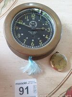 Clock and pocket watch side by side on tabletop
