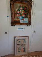 Overview of two framed artworks against a white wall: large floral painting and smaller abstract piece below