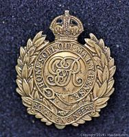 Front view of Royal Engineers WW1 1916 Economy Issue cap badge showing the brass-tone laurel wreath, crown, and detailed cypher with motto.
