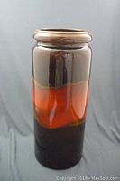 Full view of the ceramic umbrella stand showing the color gradient glaze and cylindrical shape.